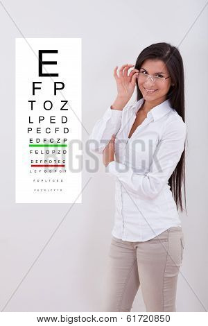 Woman Pointing Standing Nex To An Eye Chart