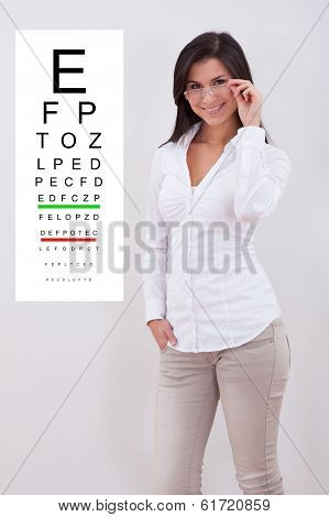 Woman Pointing Standing Nex To An Eye Chart
