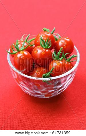 cherry tomatoes in glass bowl isolated on red background, lycopene image