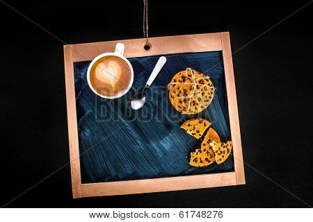 coffee latte with heart and oatcakes on chalkboard, top view