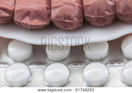 Concept Of Colesterol, Sausages On A Plate Along With Diet Pills