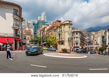 MONTE CARLO, MONACO - JULY 13, 2013: Policewoman from Urban Police Division stand on roadway near roundabout and controls traffic. National police force of Monaco consisting of 515 police officers.