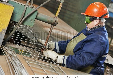 adult industrial female worker spot welder in factory workshop