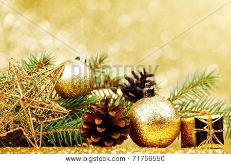 Christmas card with fir branch and decorations on golden gitter background