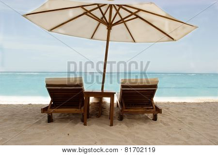 Pair of beach loungers on the deserted  ocean