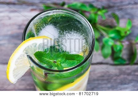 Lemonade With Fresh Lemon And Mint In Glass On Wooden Background