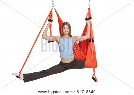 Young woman making antigravity yoga exercises in stretching twine