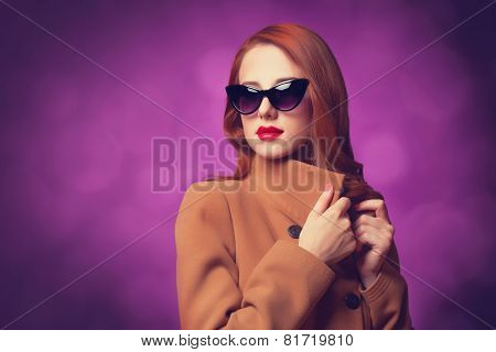 Redhead Women In Coat On Vilolet Background.