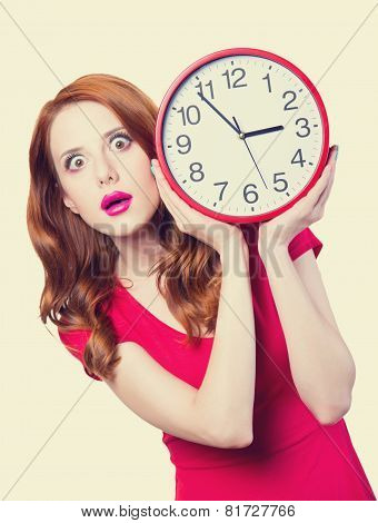 Surprised Redhead Girl With Huge Alarm Clock On Light Background.