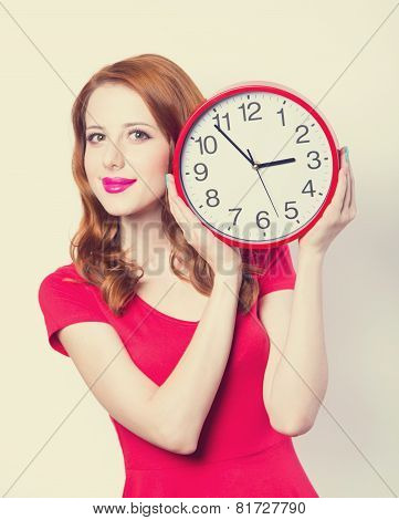 Surprised Redhead Girl With Huge Alarm Clock On Light Background.