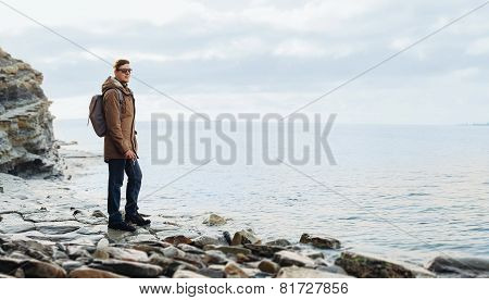 Traveler Hipster Man Standing On Coastline Near The Sea