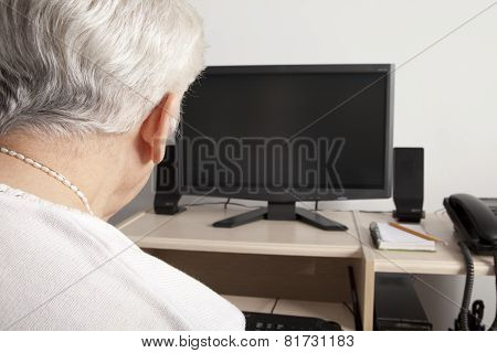 A senior person in front of his computer