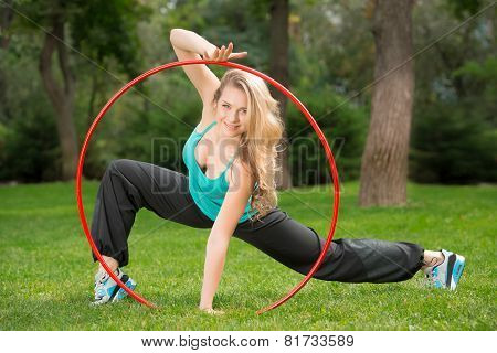 Young female athlete with hula hoop in the park