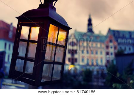 Lantern With A Yellow Light On The Background Of The Old Town