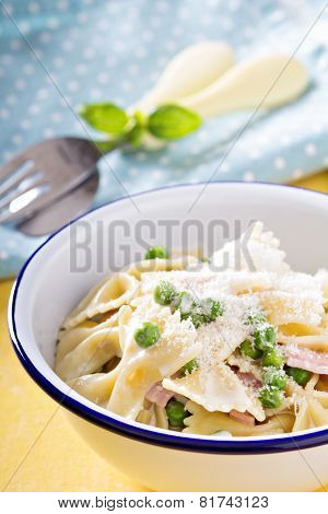 Bow ties pasta with ham and green peas