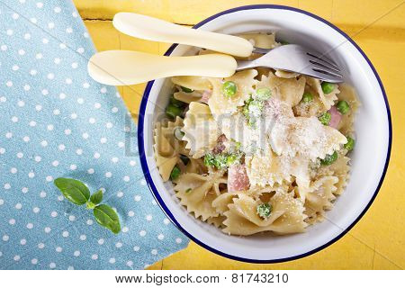Bow ties pasta with ham and green peas