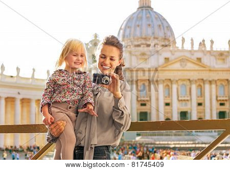 Happy Mother And Baby Girl Checking Photos In Camera In Front Of