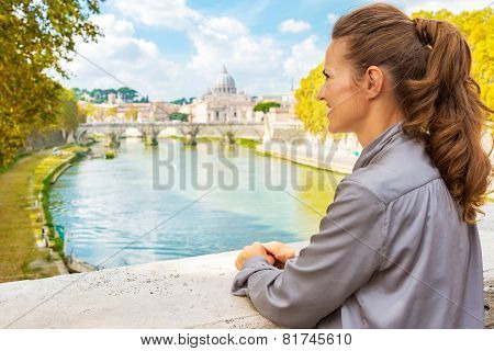 Young Woman Looking Into Distance While On Bridge With View On B