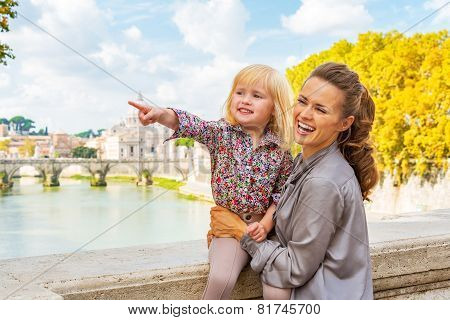Happy Mother And Baby Girl Pointing While On Bridge Ponte Umberto I With View On Basilica Di San Pie