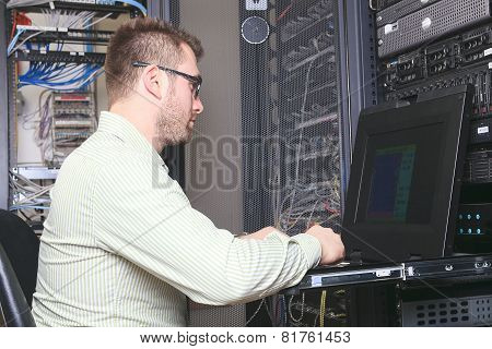 A happy worker technician at work with computer.