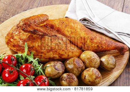 half baked chicken with new potatoes on the board