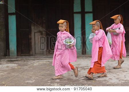 MANDALAY,MYANMAR,JANUARY 17, 2015: A group of young Buddhist nuns is walking in the streets of Mandalay, Myanmar (Burma).