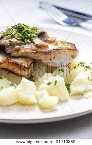 pikeperch on butter with mushroom sauce and spring potatoes