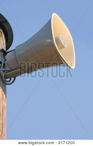 Tromba in plastica grigio sul palo sopra cielo blu