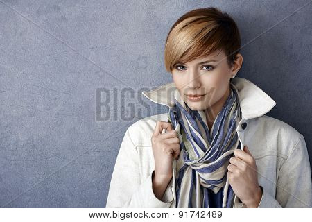 Closeup portrait of beautiful young woman wearing jacket and scarf