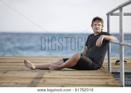 A Man Sits On The Dock