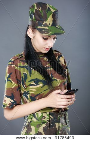 Female American Soldier Reading A Text Message