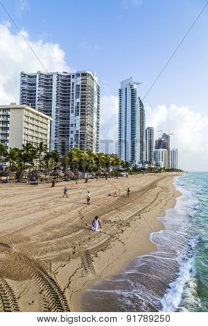 People Enjoy The Beach At Sunny Isles Beach Near The Pier