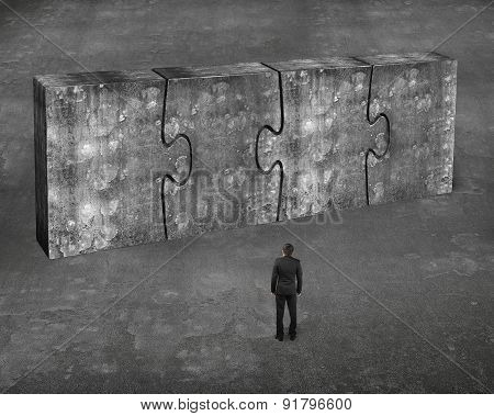 Man Facing Four Huge Concrete Puzzles Connected Together