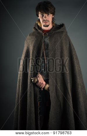wandering man in woolen cape with a sword