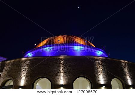A dome with the moon in the evening with yellow color haughtiness and blue.