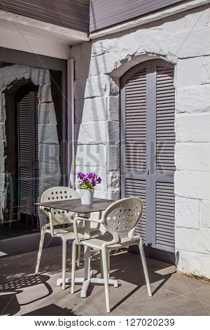 A table with two chairs in front of a grey door