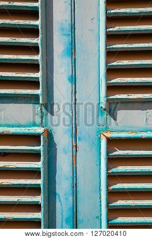 A cyan rusty window made with wood panel