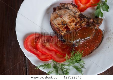 Big juicy grilled steak with greens on the plate