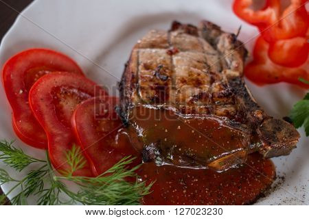 Big juicy grilled steak with greens on the plate