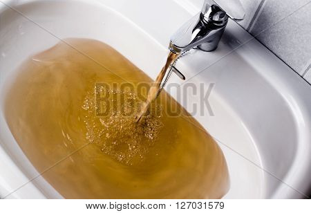 Dirty Brown Water Running Into A Sink