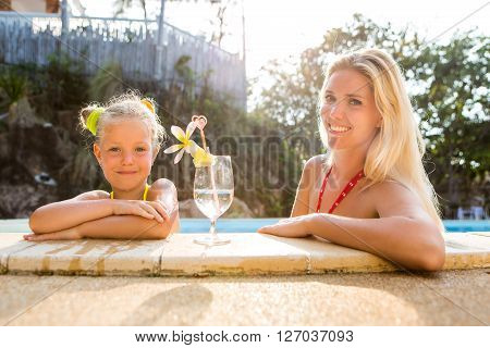 Cute Girl And Beautiful Mother At The Pool