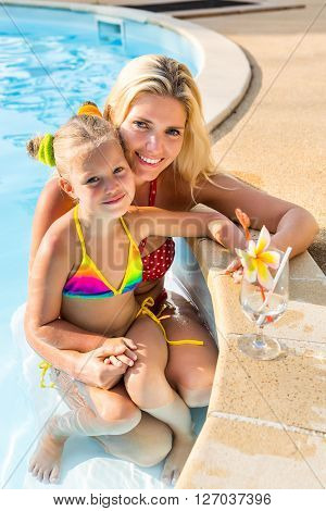 Cute Girl And Beautiful Mother At The Pool