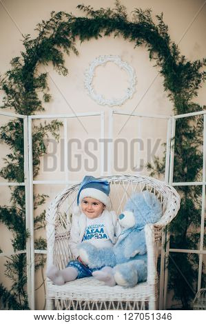 Cute little boy sitting in front of the Christmas tree