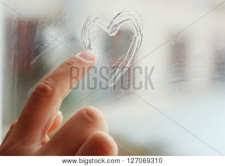 Heart drawn on the fogged glass window