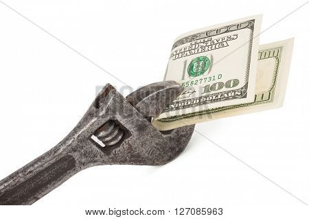 Wrench and bills of U.S. dollar currency