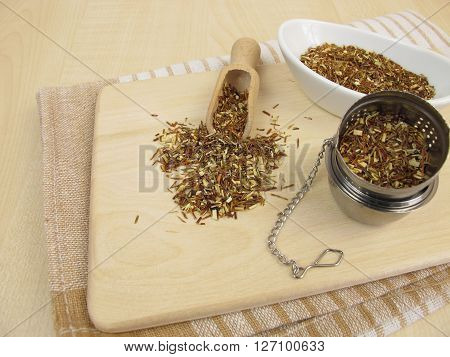Loose green rooibos tea on wooden bard