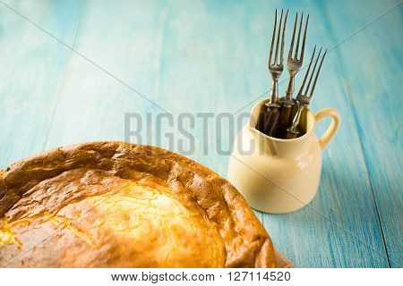 Cheese cake and three forks on over blue