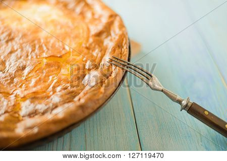 Cheese cake and one fork on over blue