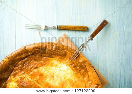 Cheese cake and two forks on over blue