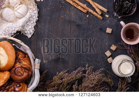 Assortment of sweet confectionery with coffee and eggs on wooden table. Copy space, top view. Bakery frame.